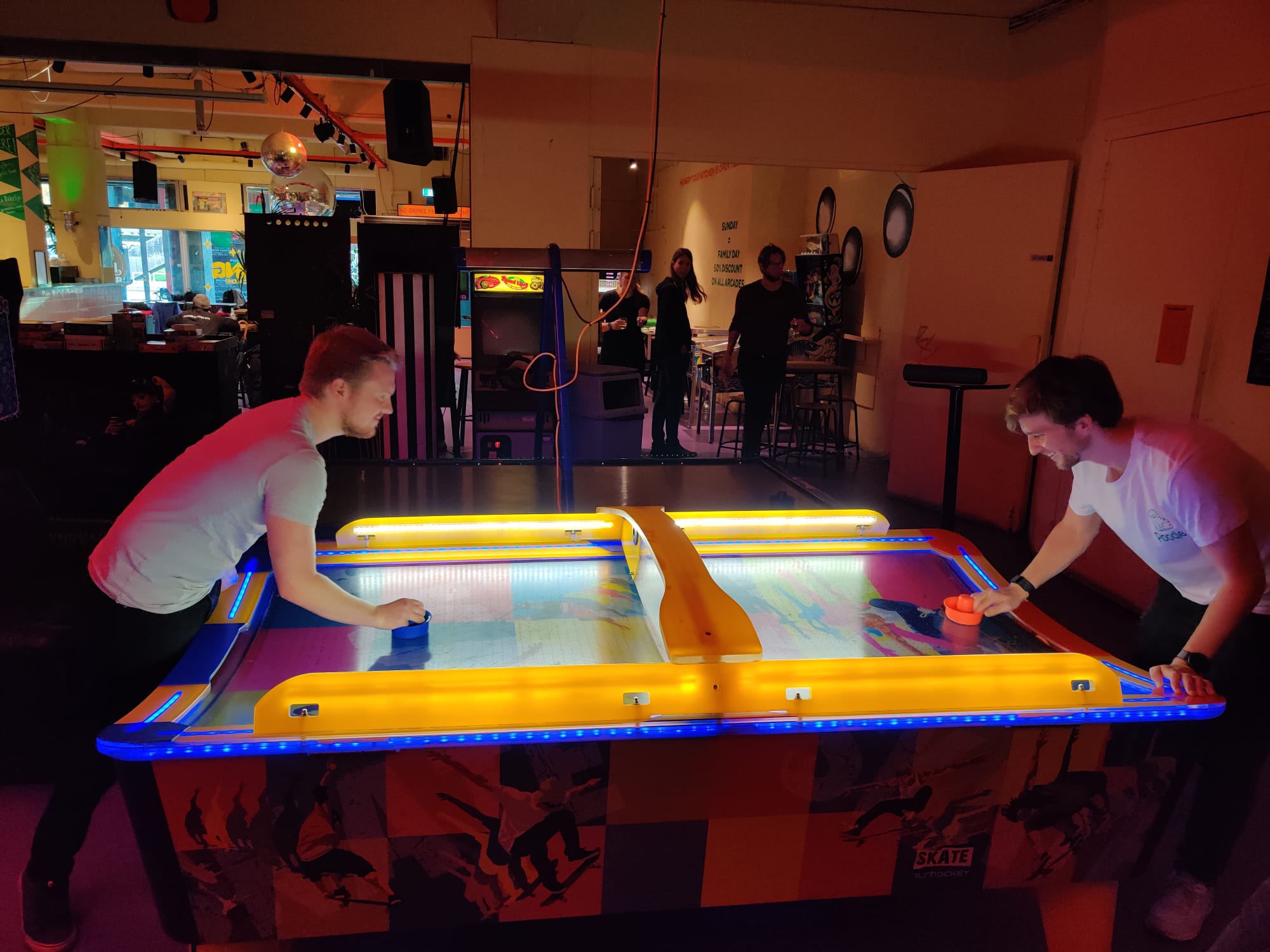 Foto van twee collega's die airhockey spelen